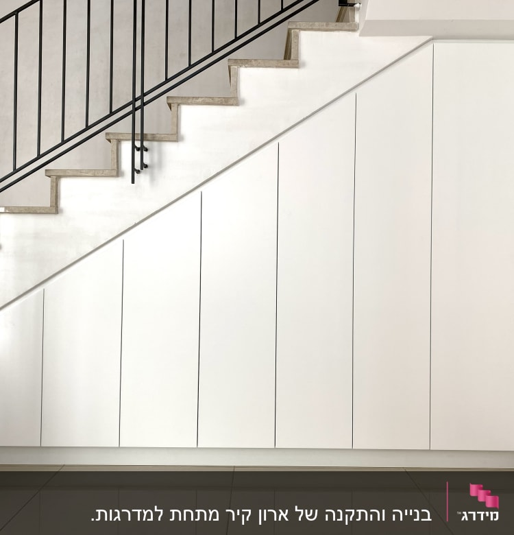 ארונות לבנים מתחת למדרגות עם דלתות אנכיות